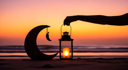Silhouette of a hand lighting a lantern on a beach at sunset