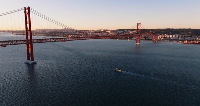 Wide drone view of 25 de Abril Bridge and Tagus River framed by Lisbon shoreline