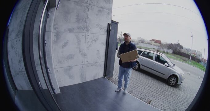 Male Courier Rings Bell and Leaves Large Box on Doorstep. Adult Man Captures Photo For Digital Proof of Delivery on Smartphone Then Walks Away. Represents Modern Contactless Service and Safety.