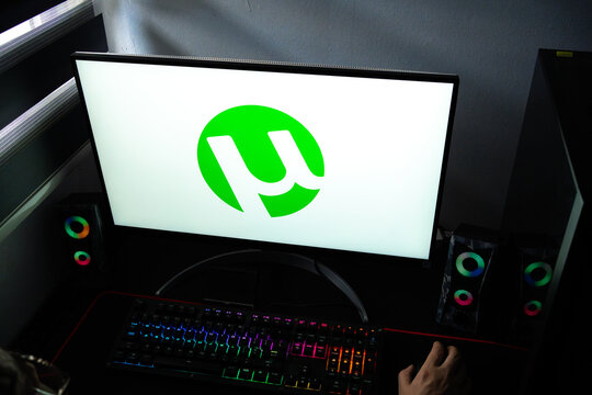 Punta Arenas, Chile &ndash; February 18, 2026: A person at a desk with the &micro;Torrent (uTorrent) BitTorrent client logo displayed on a computer monitor