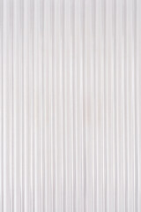 Obraz premium A full frame view of a white translucent corrugated plastic sheet with vertical ridges