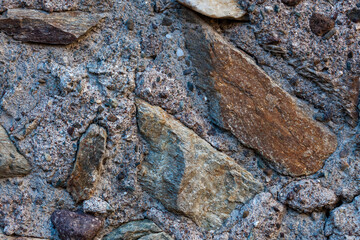 Irregular stones set in a rough mortar matrix, perfect for rustic construction and natural material textures.