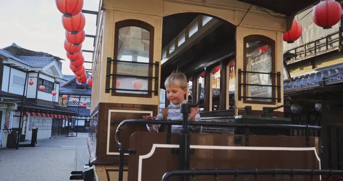 Cute little boy walking through old Japanese trolly - steady cam