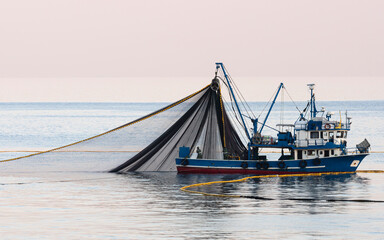 The fishing boat is casting its nets into the sea hoping for a good catch. © Güven CAN