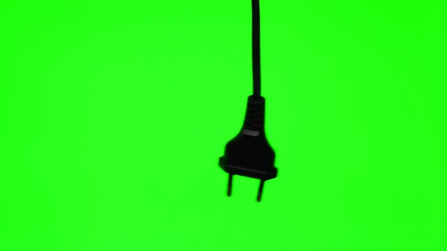 A close-up of a 220-volt high-voltage electrical plug.
A black electrical plug for an EA socket against a green background.