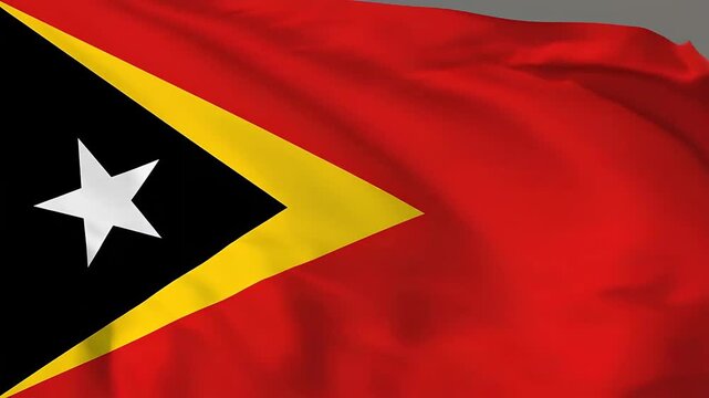 The flag of East Timor waves gently in the wind, showcasing its vibrant colors.