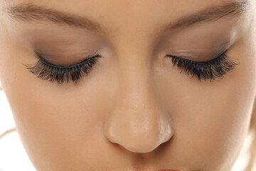 Naklejka premium Studio shot close-up of a woman’s closed eyes with artificial eyelashes and makeup on a white background
