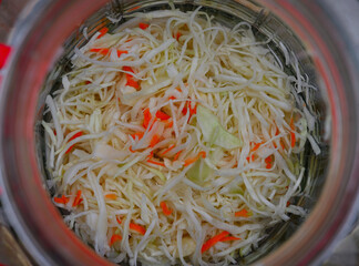 Biała kapusta poszatkowana w słoju. Kiszenie kapusty domowej roboty © Hanna