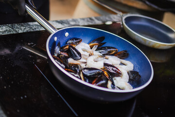Apetyczne małże i krewetki smażone na patelni © Artur