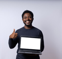 Black Brazilian man with a laptop against a neutral white background.