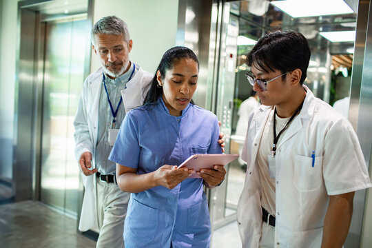 Medical team reviewing patient data in hospital hallway
