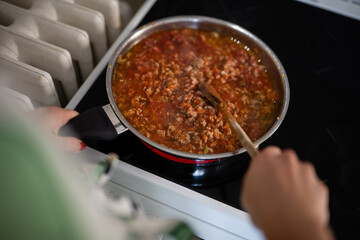Preparing bolognese sauce in a pan on a stove