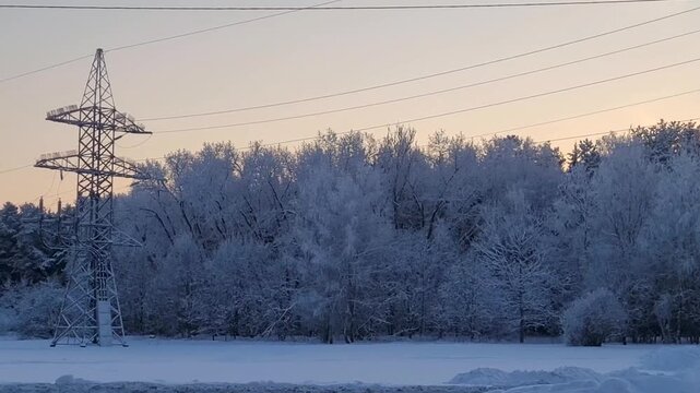 High-voltage transmission tower in the winter forest