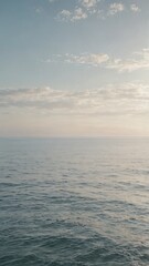 Fototapeta premium Calm sea horizon under soft cloudy sky at sunset