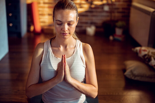 Young woman practicing yoga meditation at home