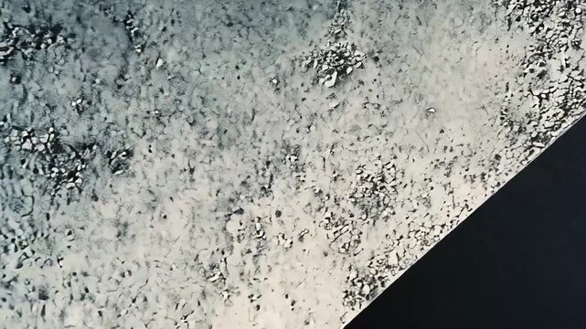 Concrete textured surfaces forming sharp angular shapes with strong contrasts of light and shadow, creating a modern abstract background emphasizing depth and structure