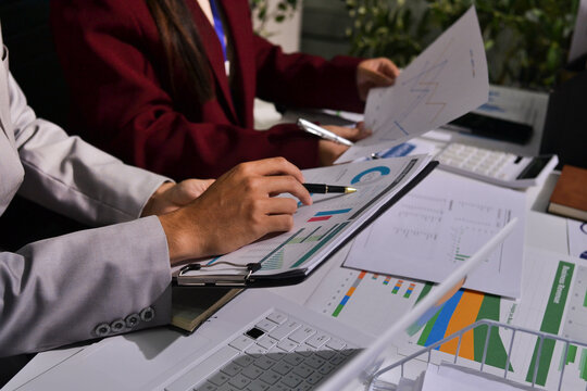 Business people analyzing monthly budget and financial report using data and chart to strategize and plan for their future business while working together in the office.