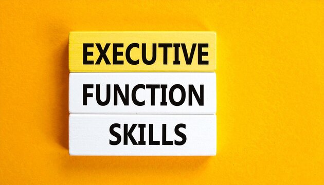 Overhead View of White Wooden Blocks Titled "EXECUTIVE FUNCTION SKILLS" Arranged on a Vibrant Yellow and Brown Background