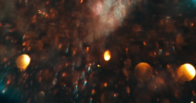 Slow Motion Of Golden Particles Illuminating In Liquid. Abstract Scientific Fluid Motion
