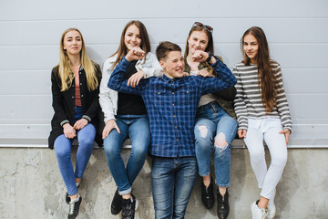 Fototapeta premium Young people friends together, flexing muscles and smiling, showing friendship, unity, and teamwork in an urban setting