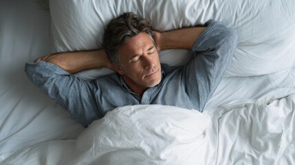 Obraz premium Caucasian mature male sleeping peacefully in bed with hands behind head.