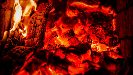 Intense Closeup of Glowing Red Hot Coals and Roaring Fire Flames in Darkness