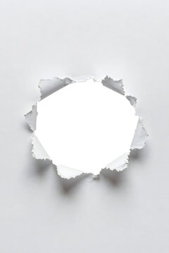 A torn paper edge with a white center on a gray background, viewed from directly above, showcasing a ripped texture and shadow effect