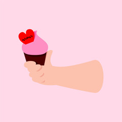 A hand holds a cupcake with a heart and the inscription Mom for Mother's Day