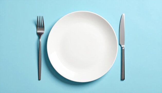 Empty white plate with fork and knife on solid light blue background view