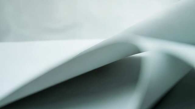 Smooth paper sheets forming graceful curves and subtle shadows on a clean seamless background, highlighting concepts of flow, simplicity, and modern design