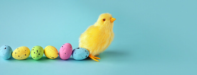 Easter decoration of a yellow chick with a row of colorful painted Easter eggs. © Belight