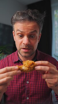 Guilty pleasure. Man eating fried chicken leg, enjoying fast food.