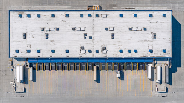 A large industrial warehouse with loading docks and parking area.