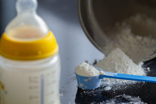 Baby formula, infant formula, baby milk bottle, scoop of milk powder, tipped-over can