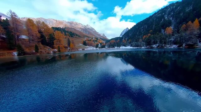 Low Angle Drone Shot of Turquoise Alpine Lake Reflecton with Autumn Trees