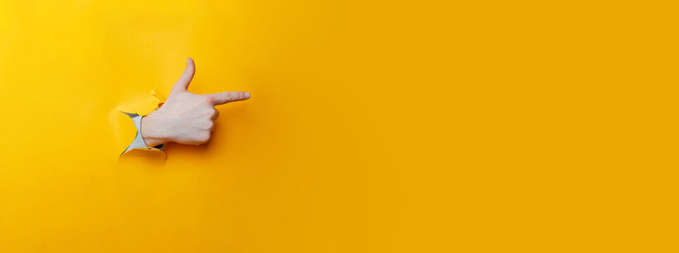 Index Finger Pointing Through Ripped Yellow Paper, Casual Confident Gesture, Communication Cue For Pitch