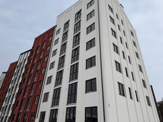 Modern brick facade apartment building exterior with large windows. Residential architecture concept for urban development and property design.
