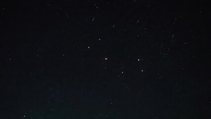 Night sky with stars and constellations over dark horizon.