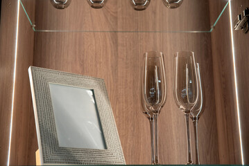 Modern cabinet display with wine glasses and mockup frame