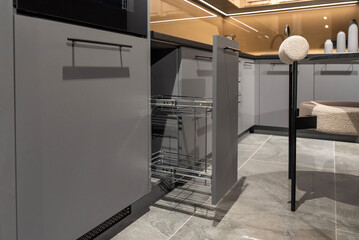 Pull-out kitchen cabinet with empty chrome cargo basket