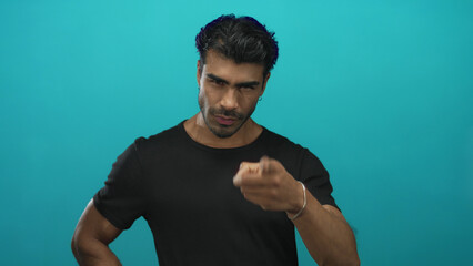 Young man wearing black t shirt pointing finger at camera in studio with serious expression and upright posture  determination. © Krakenimages.com