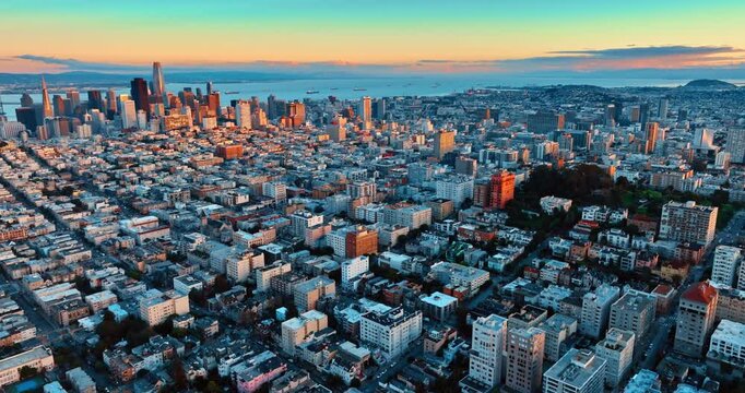 Footage over the cityscape of modern San Francisco, California, USA. Approaching the high-rise downtown lit by the setting sun.