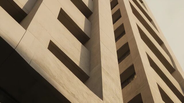 Brutalist architecture building featuring geometric shapes and robust concrete surfaces creating deep shadows and an imposing minimalist aesthetic under natural light