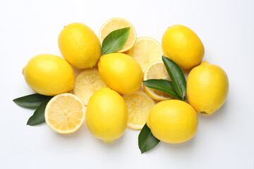 Fresh yellow lemons and green leaves on white background, flat lay