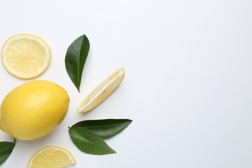 Fresh lemon fruits and green leaves on white background, flat lay. Space for text