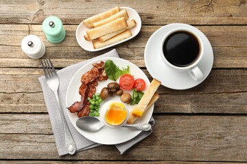 Tasty breakfast with soft boiled egg and bacon served on wooden table, flat lay