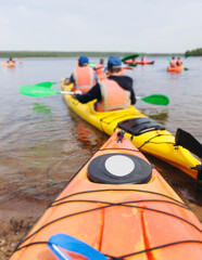 Kayaking in the lake, colorful canoe kayak boat paddling, canoeing in river, scandinavian skerries landscape, group of tourists athletes in kayaks floating, kayakers rowing during water sports tour