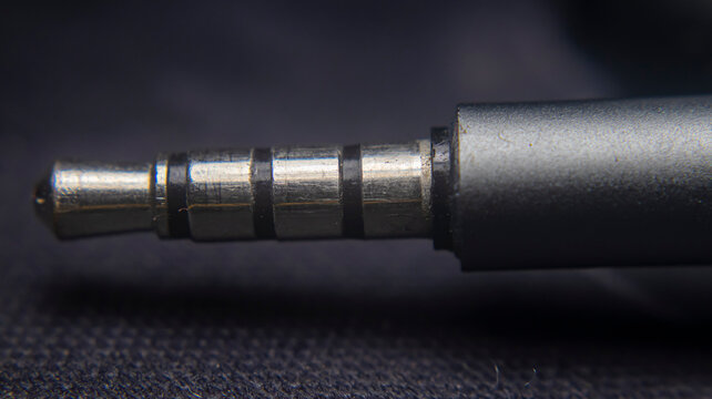 Close up of 3.5mm stereo jack splitter with 4 ports and mic support, TRRS audio connector for headset, enabling multiple audio and microphone connections.