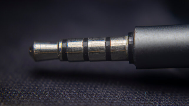 Close up of 3.5mm stereo jack splitter with 4 ports and mic support, TRRS audio connector for headset, enabling multiple audio and microphone connections.