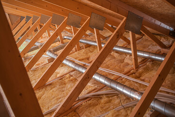View of Attic With Insulation and Ventilation Pipes